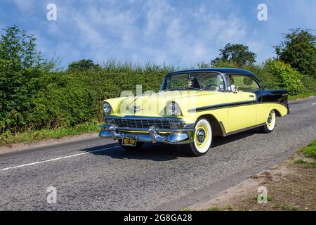 1956 50s Yellow American Chevrolet Chevy GMC Bel-air 4300cc petrol 2dr coupe en-route to Capesthorne Hall classic July car show, Cheshire, UK Stock Photo