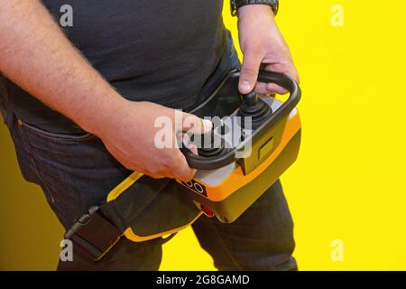 Worker Holding Remote Control With Joysticks for Construction Machinery Stock Photo