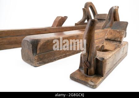 High angle studio shot of three vintage wood planers of different sizes, isolated on white background. Old carpenter tools with wood worm holes Stock Photo