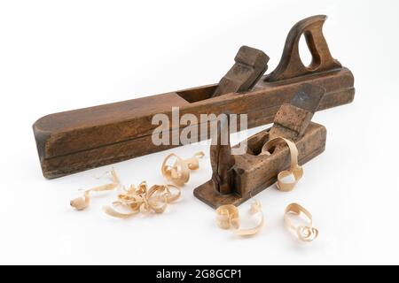 High angle studio shot of two vintage wood planers of different sizes, isolated on white background. Old carpenter tools with wood worm holes. Thin Stock Photo