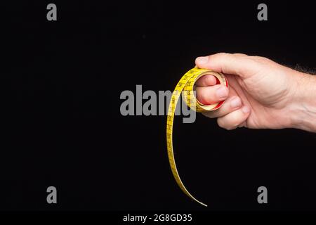 Tailor's and dressmaker's tape measure, flexible, yellow, for measuring parts of the human body to create suits and dresses. Stock Photo