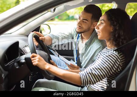 Handsome arab man driving instructor holding steering wheel Stock Photo
