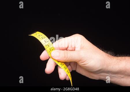 Tailor's and dressmaker's tape measure, flexible, yellow, for measuring parts of the human body to create suits and dresses. Stock Photo