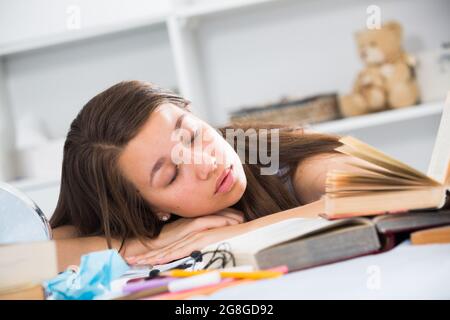 Tired girl fell asleep when she was studying Stock Photo