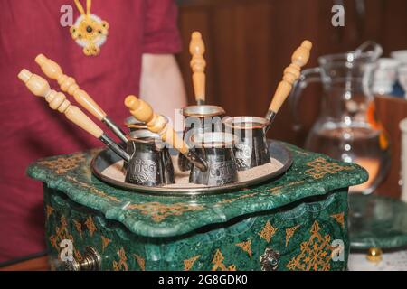 Turkish coffee brewed on sand in cezve. Oriental, east coffee. Stock Photo