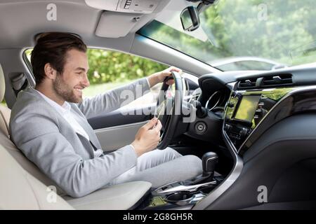 european man in suit is driving in city and looking at gps map Stock Photo