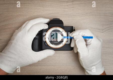 Removing sensor dust from a modern digital full frame camera sensor Stock Photo