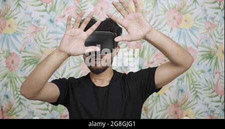 Man wearing a virtual reality headset seem to be defending himself with hands in front of him Stock Photo