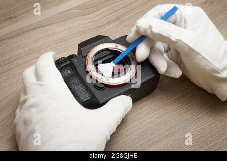 Removing sensor dust from a modern digital full frame camera sensor Stock Photo