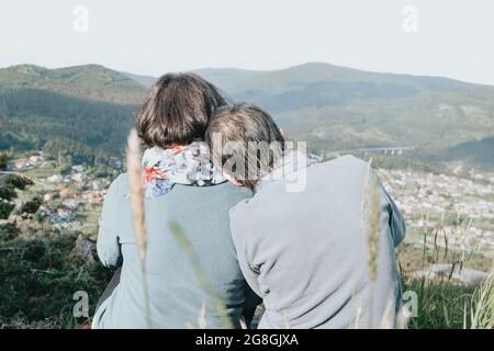 Senior woman and her daughter bonding together while enjoying a valley view on a sunny day Stock Photo