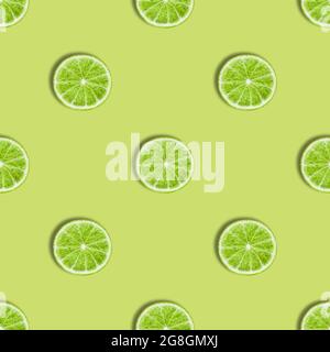 Seamless pattern with lime on a green background. Lime slices seamless texture for the design. Summer background. Top view, flat lay. Stock Photo