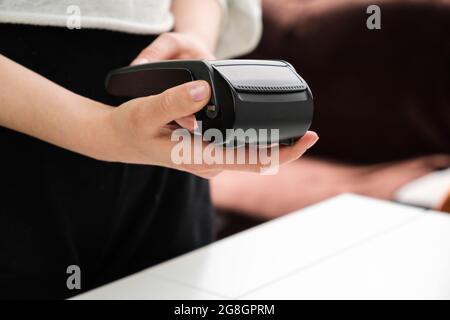 Female hand holding pos terminal for contactless payment. Stock Photo