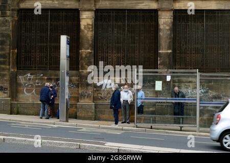 SHEFFIELD. SOUTH YORKSHIRE. ENGLAND. 07-10-21. Waingate, people waiting at a bus stop.