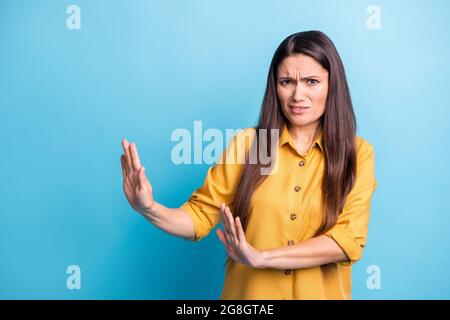 Photo portrait of brunette with long hair in yellow shirt refusing rejecting isolated on vibrant blue color background Stock Photo