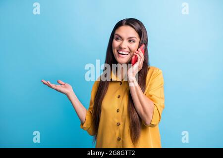 Photo portrait of laughing woman talking on cellphone looking at blank space isolated on bright blue color background Stock Photo