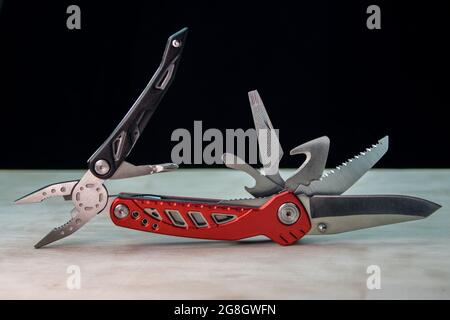 Beautifil red-black Multitool on white surface Black background Stock Photo
