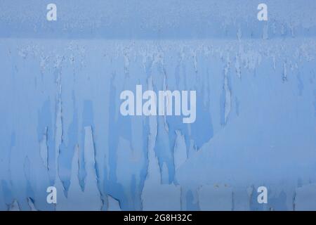 peeling off old blue paint on vehicle - close-up with selective focus. Stock Photo