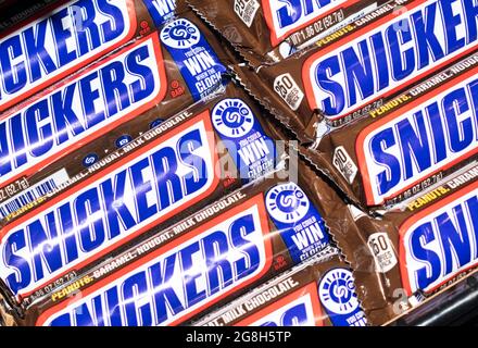 Houston, Texas USA 05-17-2020: Snickers bars in wrappers lined up on an angle in rows, flat lay format. Chocolate confectionary made by Mars Inc. Stock Photo