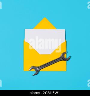 Happy father's day banner with copy space. Man or husband concept. Yellow Envelope and wrench on blue background. Happy labor day. Stock Photo