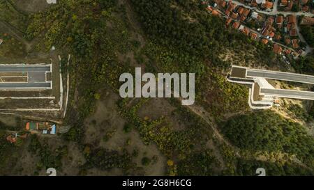 Tunnel enters on one side of the hill exits on the other Aerial Drone top-down shot Stock Photo