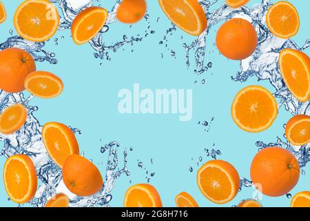 Frame of sliced fresh orange with splash of water on a blue background. Vitamins, healthy diet and detox concept. Water splashing on Sliced oranges fl Stock Photo