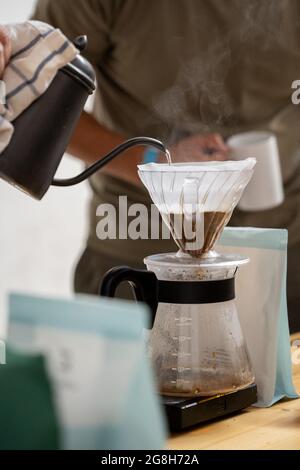 Preparing V60 coffee, pouring hot water over coffee, filter coffee, coffee drip Stock Photo