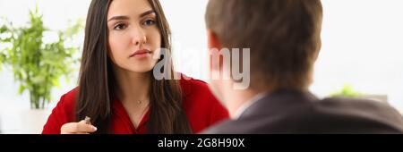 A man in a suit conducts an interview with a woman Stock Photo