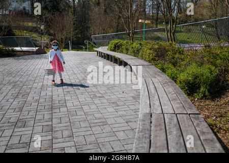 Girl on easter egg hunt in public park Stock Photo