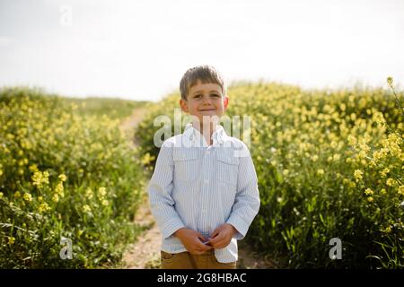 Young Boy Standing in Wildflower Field Stock Photo