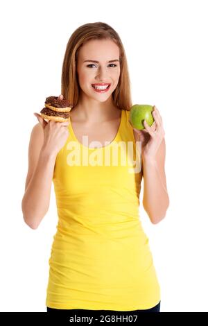 Woman holding an apple with one hand and donuts on another hand finger on a white background Stock Photo