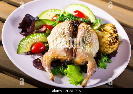 tobacco salad Image of quail-tobacco with sesame which served with salad of avocado and  greenery Stock Photo