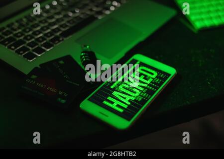 Mobile phone with laptop, credit cards and padlock at workplace of hacker Stock Photo