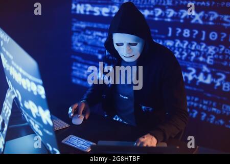 Hacker using computers in dark room Stock Photo