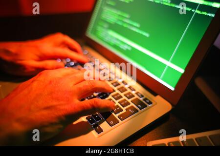 Hacker using computer in dark room Stock Photo