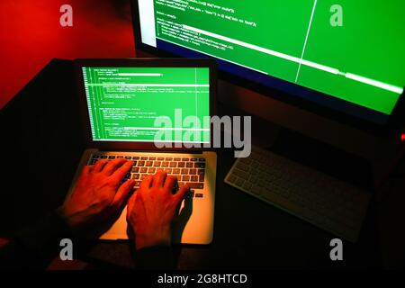 Hacker using computer in dark room Stock Photo
