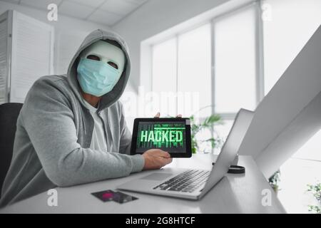 Hacker using computers in room Stock Photo