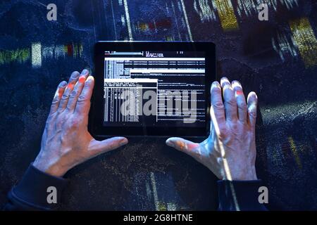 Hands of hacker with tablet computer on dark background Stock Photo