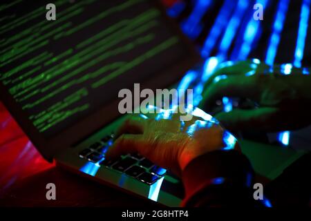 Hacker using computer in dark room Stock Photo