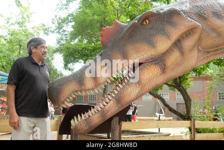 Leipzig, Germany. 20th July, 2021. Don Lessem, paleontologist and author, stands in front of a model of Spinosaurus at Leipzig Zoo. The life-size likeness is part of the exhibition 'The Gigantic Dino Adventure' on display there. Don Lessem also worked as a consultant for the film Jurassic Park. Credit: Sebastian Willnow/dpa-Zentralbild/dpa/Alamy Live News Stock Photo