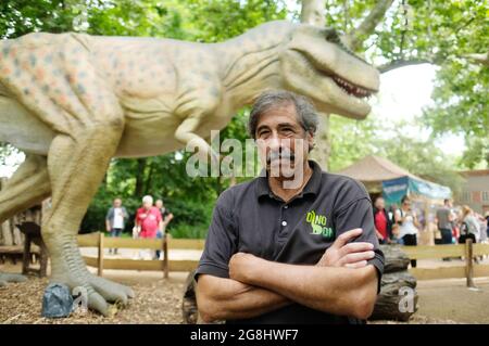 Leipzig, Germany. 20th July, 2021. Don Lessem, paleontologist and author, stands in front of a model of Tyrannosaurus rex at Leipzig Zoo. The life-size likeness is part of the exhibition 'The Gigantic Dino Adventure' on display there. Don Lessem also worked as a consultant for the film Jurassic Park. Credit: Sebastian Willnow/dpa-Zentralbild/dpa/Alamy Live News Stock Photo