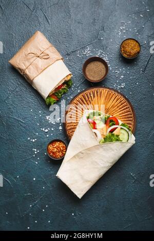 Tasty doner kebabs, sauce and spices on dark background Stock Photo