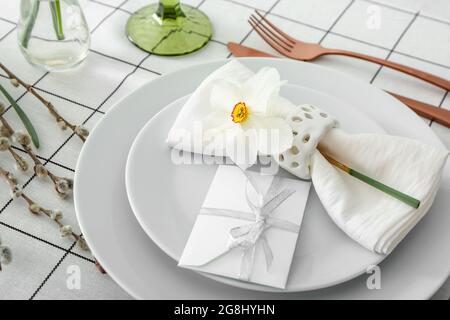 Beautiful table setting with narcissus flower Stock Photo