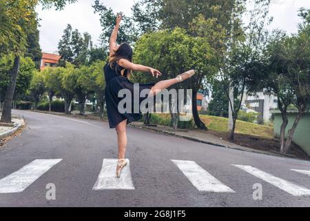 Ballet dancer performing graceful figure dance on one leg with pointe shoes Stock Photo