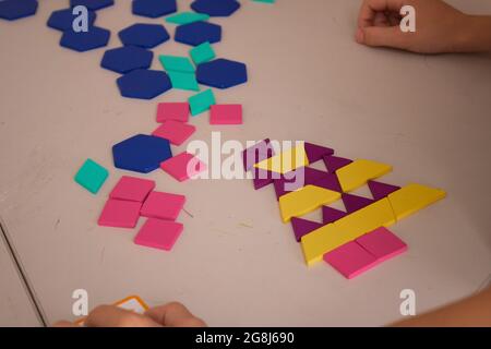 Colorful plastic bricks on table with kids hands Stock Photo
