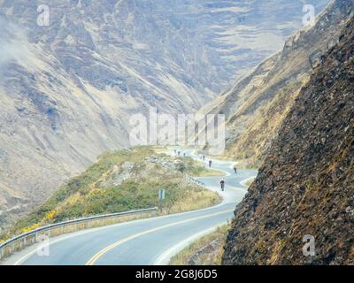 Mountain bikers riding the famous downhill trail Road of death in Bolivia. Stock Photo