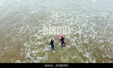 Two surfers sail on the boards in a calm ocean, top view. Stock Photo