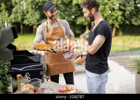 Two guys grilling at backyard Stock Photo