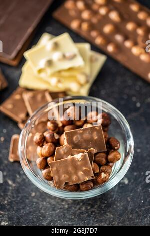 Chocolate bar with hazelnuts on black table. Stock Photo