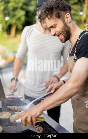 Two guys grilling at backyard Stock Photo