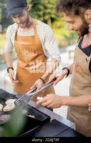 Two guys grilling at backyard Stock Photo